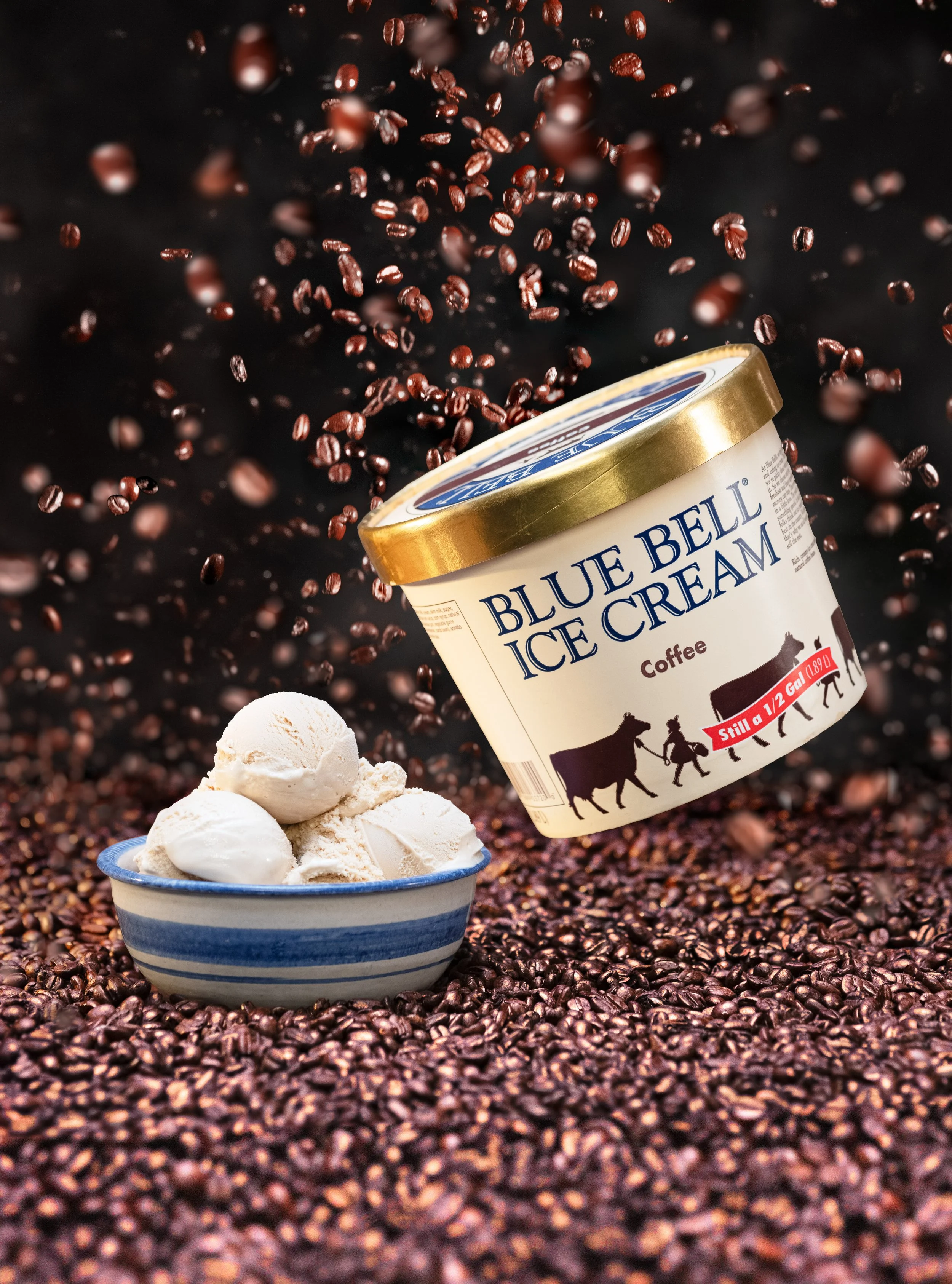 Blue Bell coffee ice cream tub with a scoop in a bowl among coffee beans