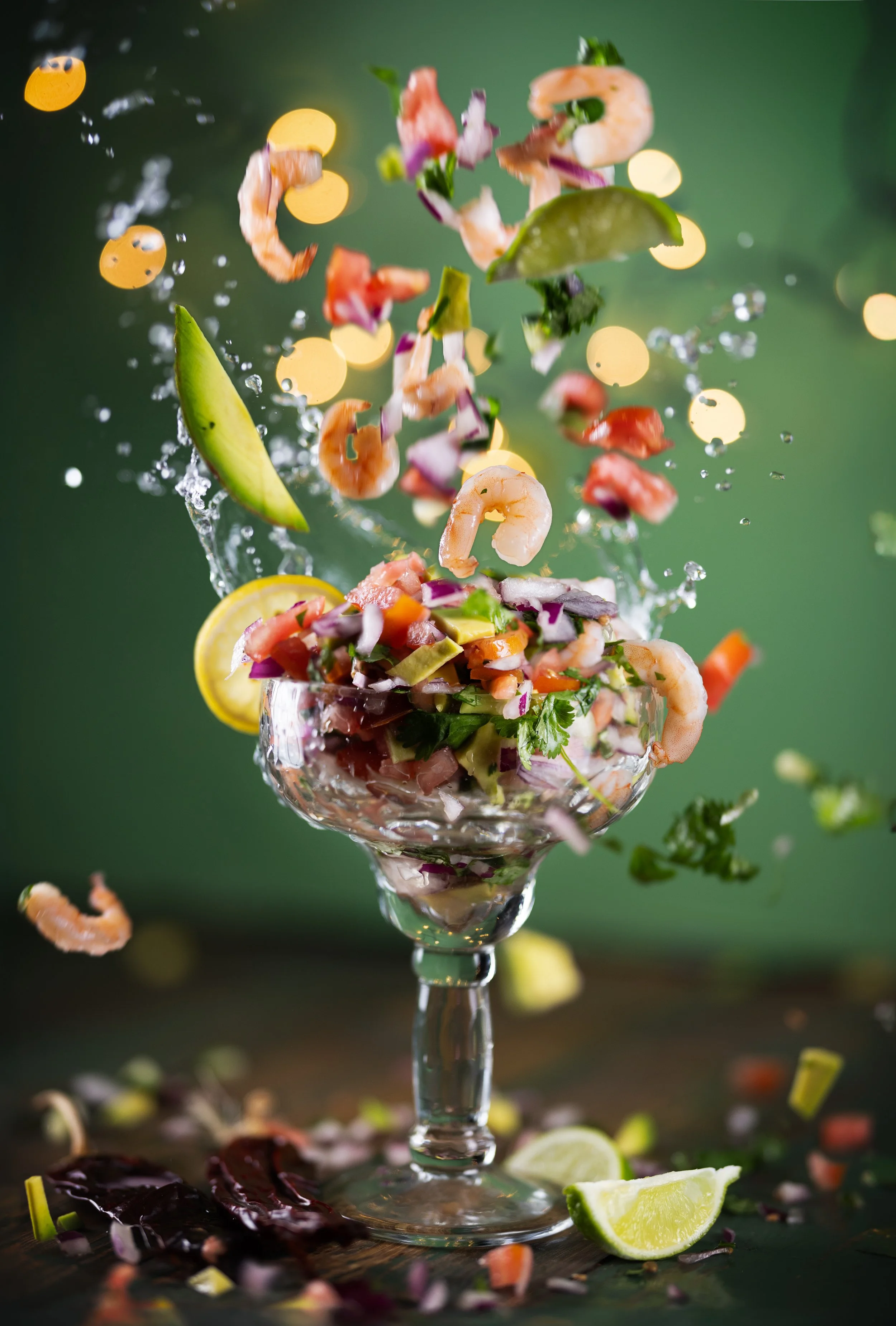 Shrimp ceviche in a glass with lime and cilantro splashing