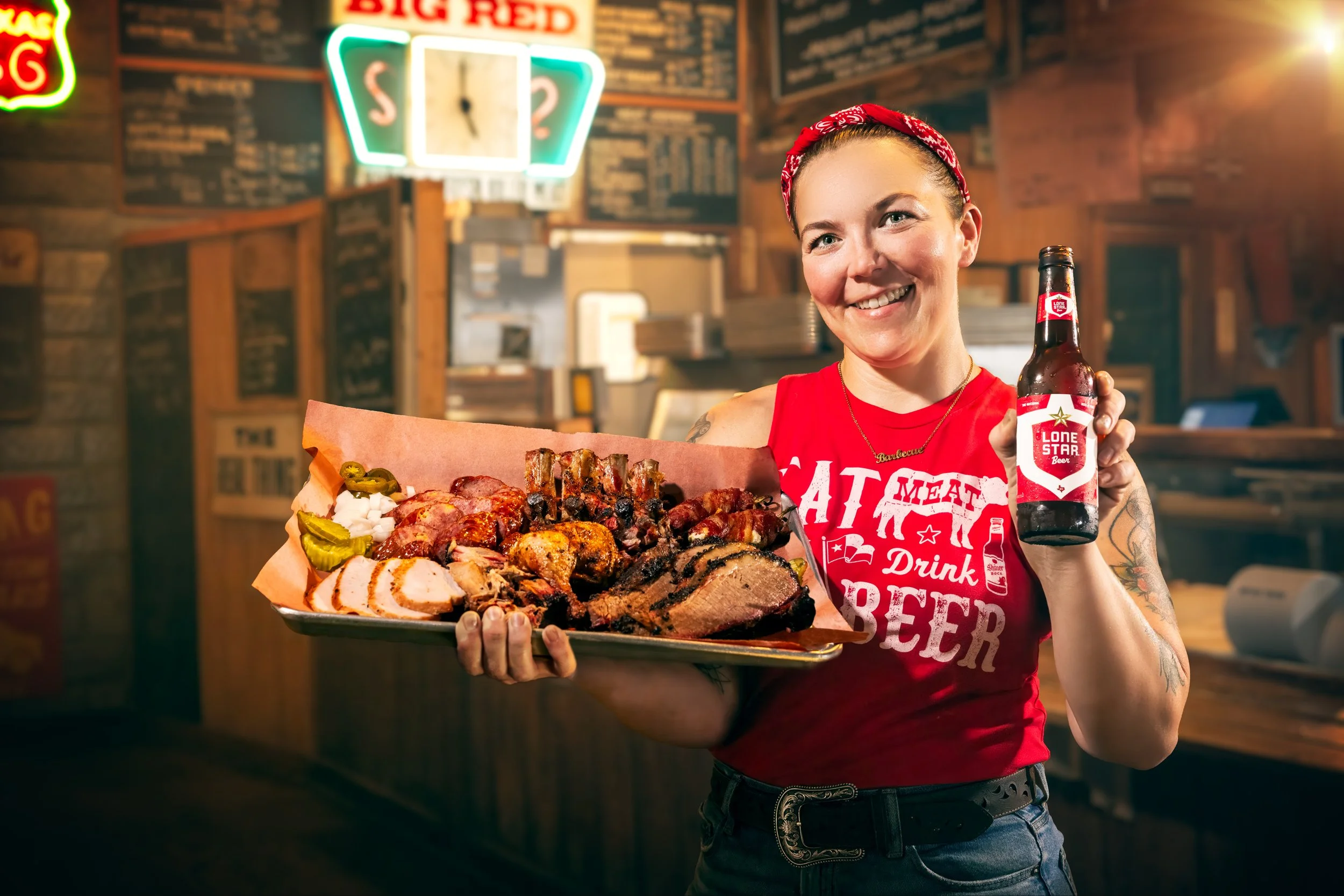 Woman holding a barbecue platter and a Lone Star beer