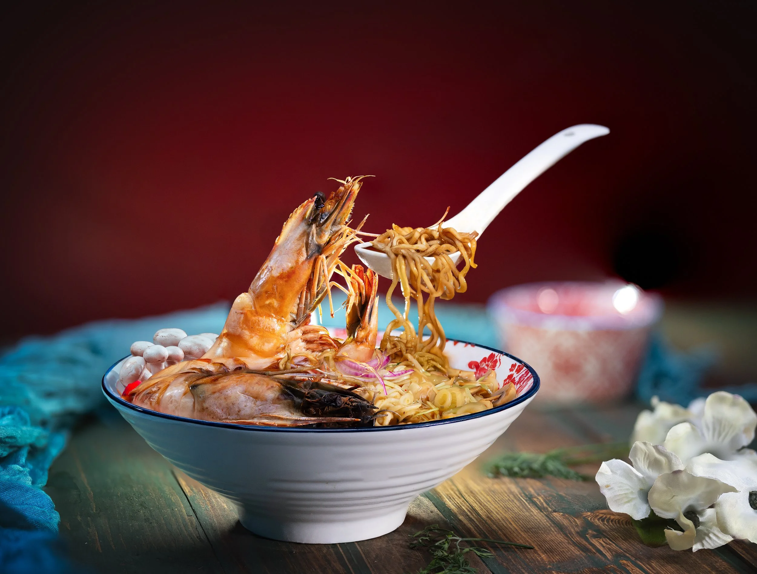 Prawn noodle soup in a white bowl with a spoon
