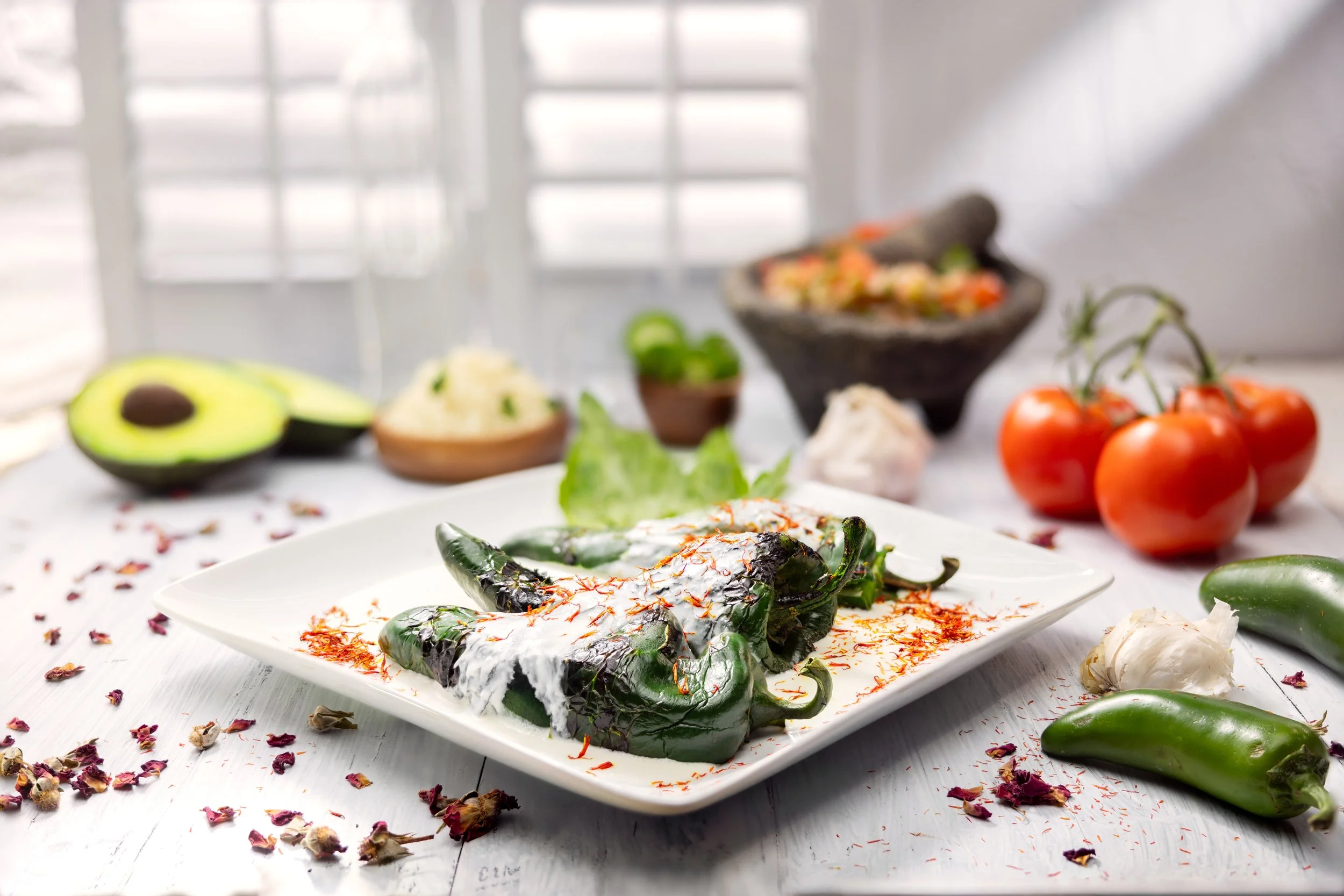 Stuffed poblano peppers with cream sauce and avocado