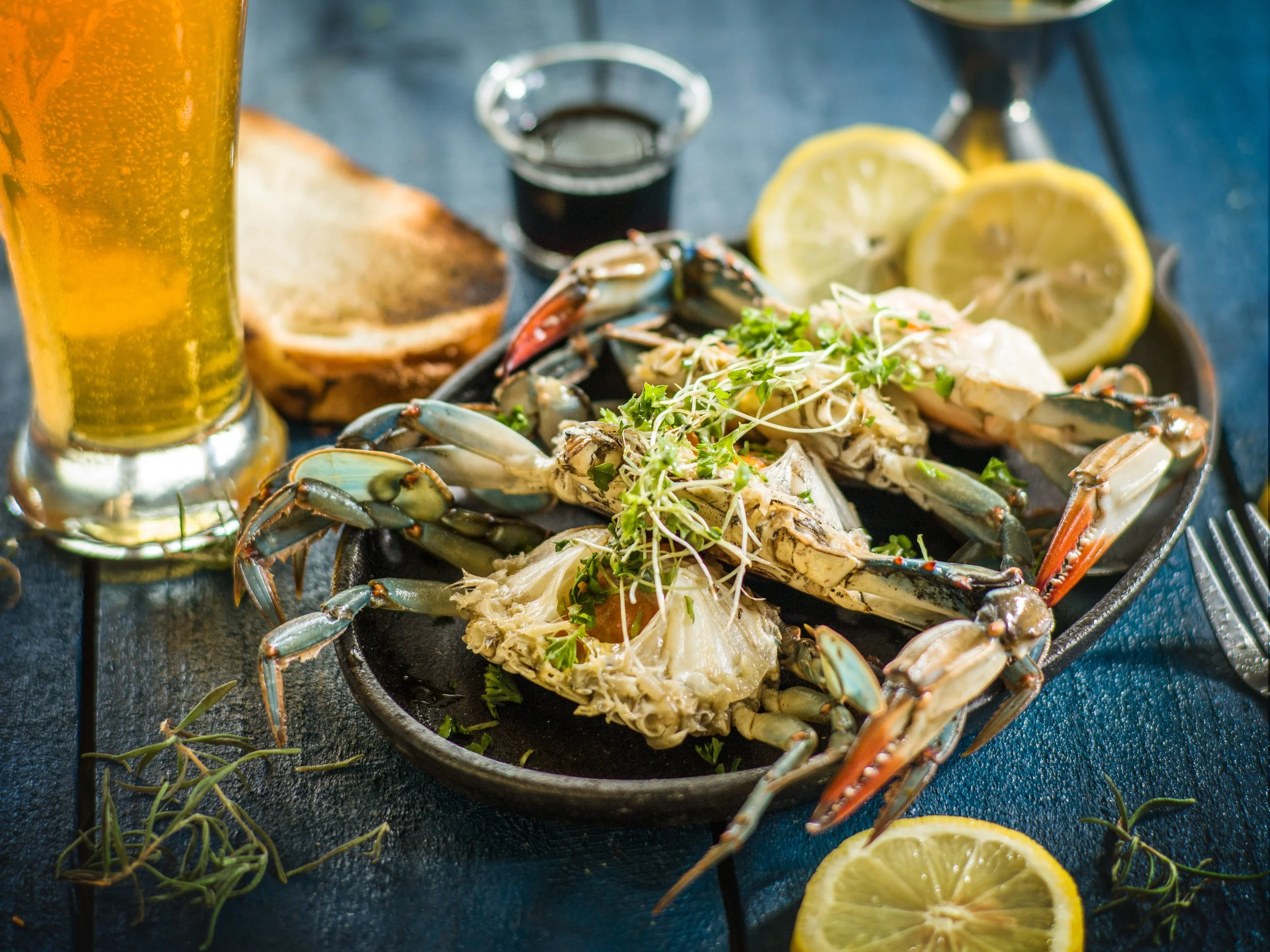 Blue crab with lemon, herbs, toast, and a glass of beer