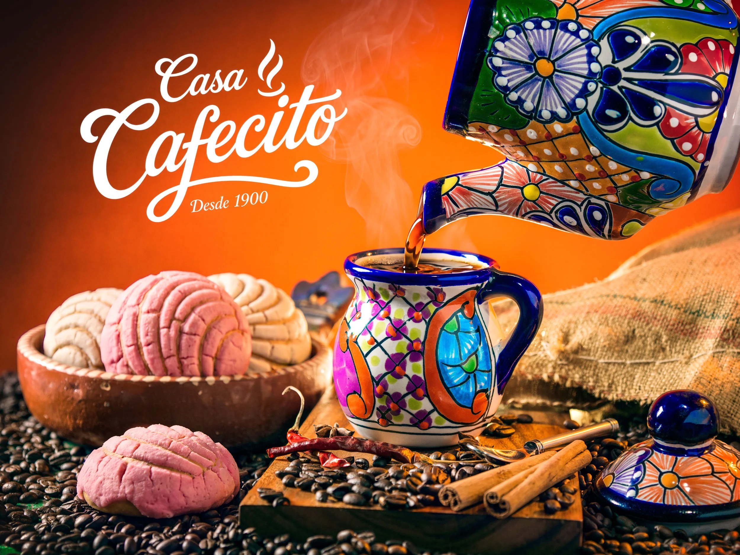 Casa Cafecito coffee pot pouring into a cup beside pan dulce and coffee beans